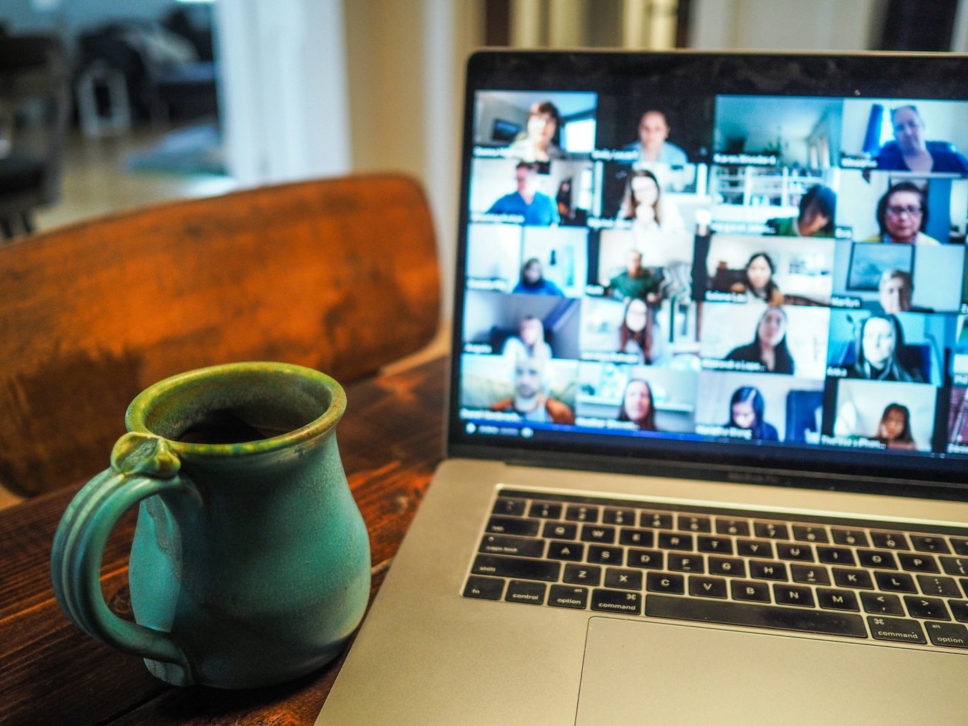 A laptop open for an online session, with a cup of tea beside it